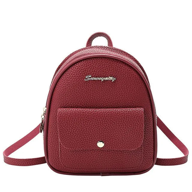 Compact black PU leather women's shoulder backpack worn crossbody, showing zipper closure and simple design.