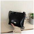 Women's casual crossbody bucket bag in black PU with sandwich pocket and silver hardware