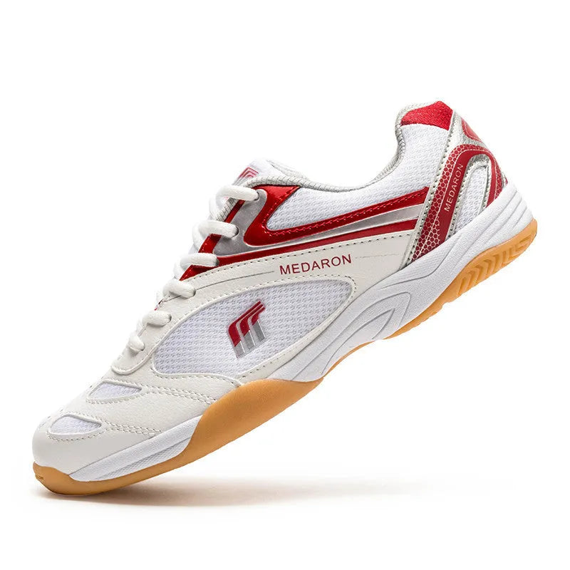 White table tennis sneakers with red trim, showing round toe and lace-up front.