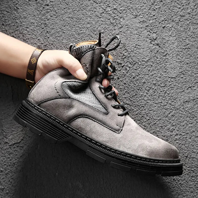 Men's ankle-high Martin boots in frosted grey leather with a thick rubber sole and round toe on a wooden floor.