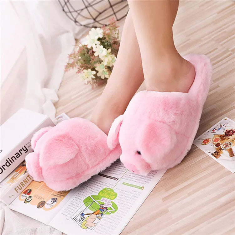 Pink pig-themed plush house slippers for adults on a plain background.
