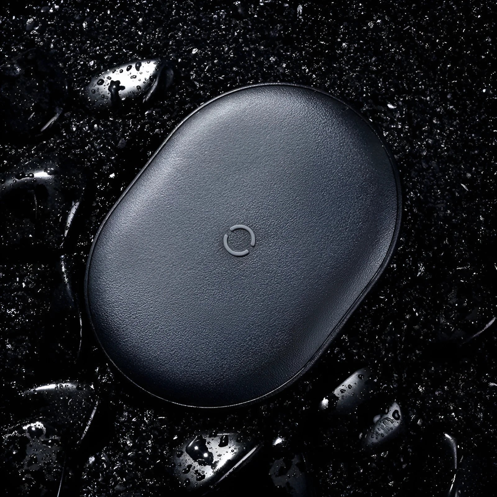 Baseus Rough 15W wireless charging pad in black on a table next to a mobile phone.