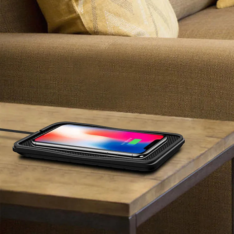 Black universal wireless car charger mount on a car air vent, charging a smartphone.