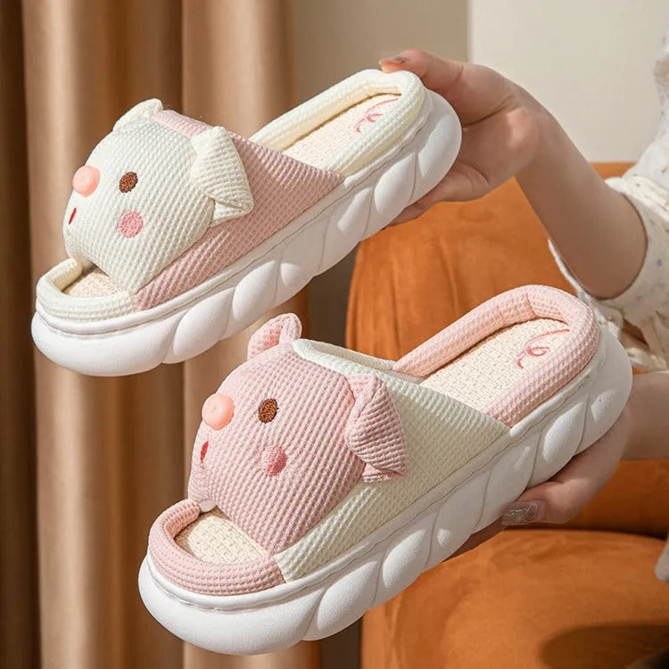 A pair of Piggy Cute linen couple slippers in open toe flip flop style on a plain background.