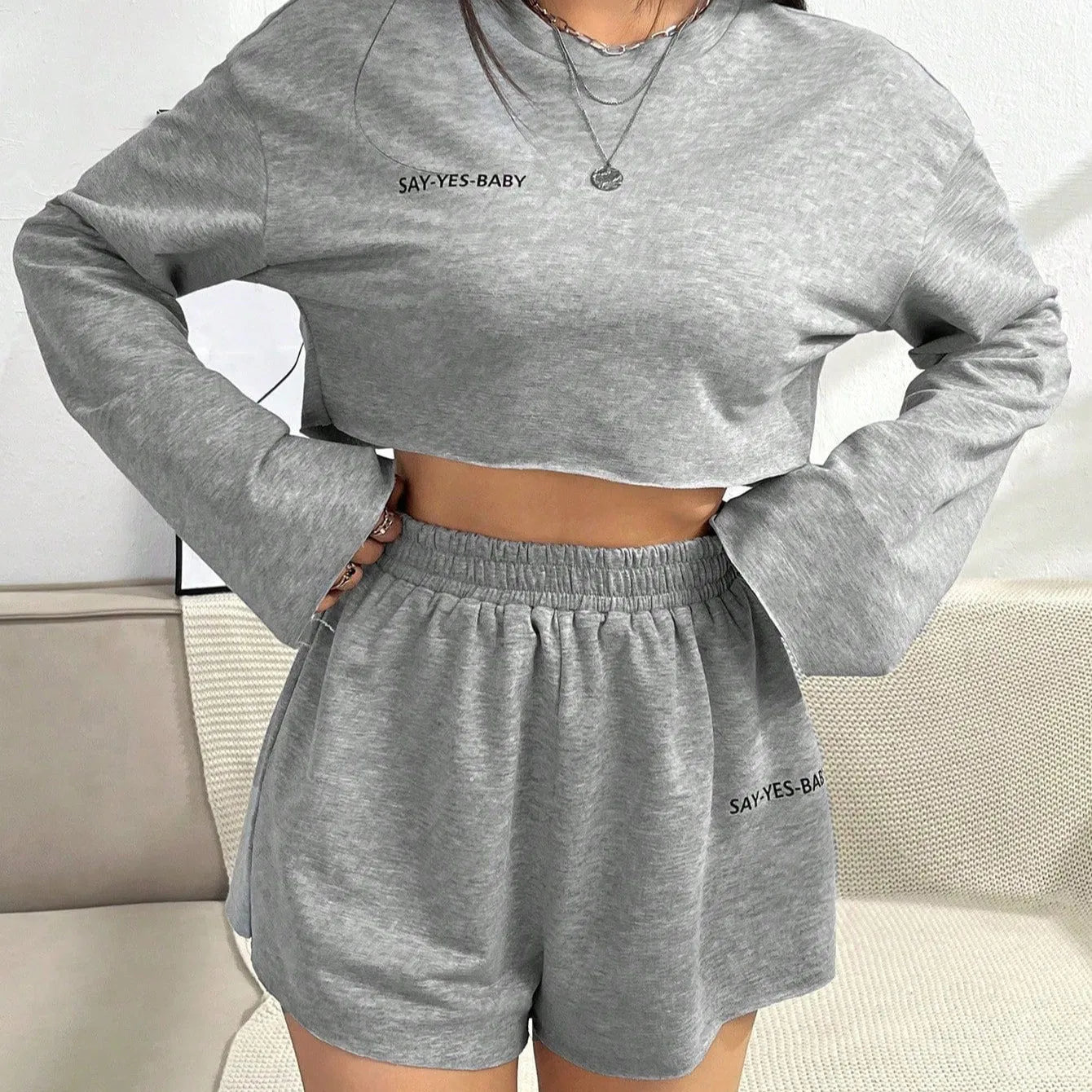 Grey women's long-sleeved T-shirt and matching shorts sleepwear set laid flat
