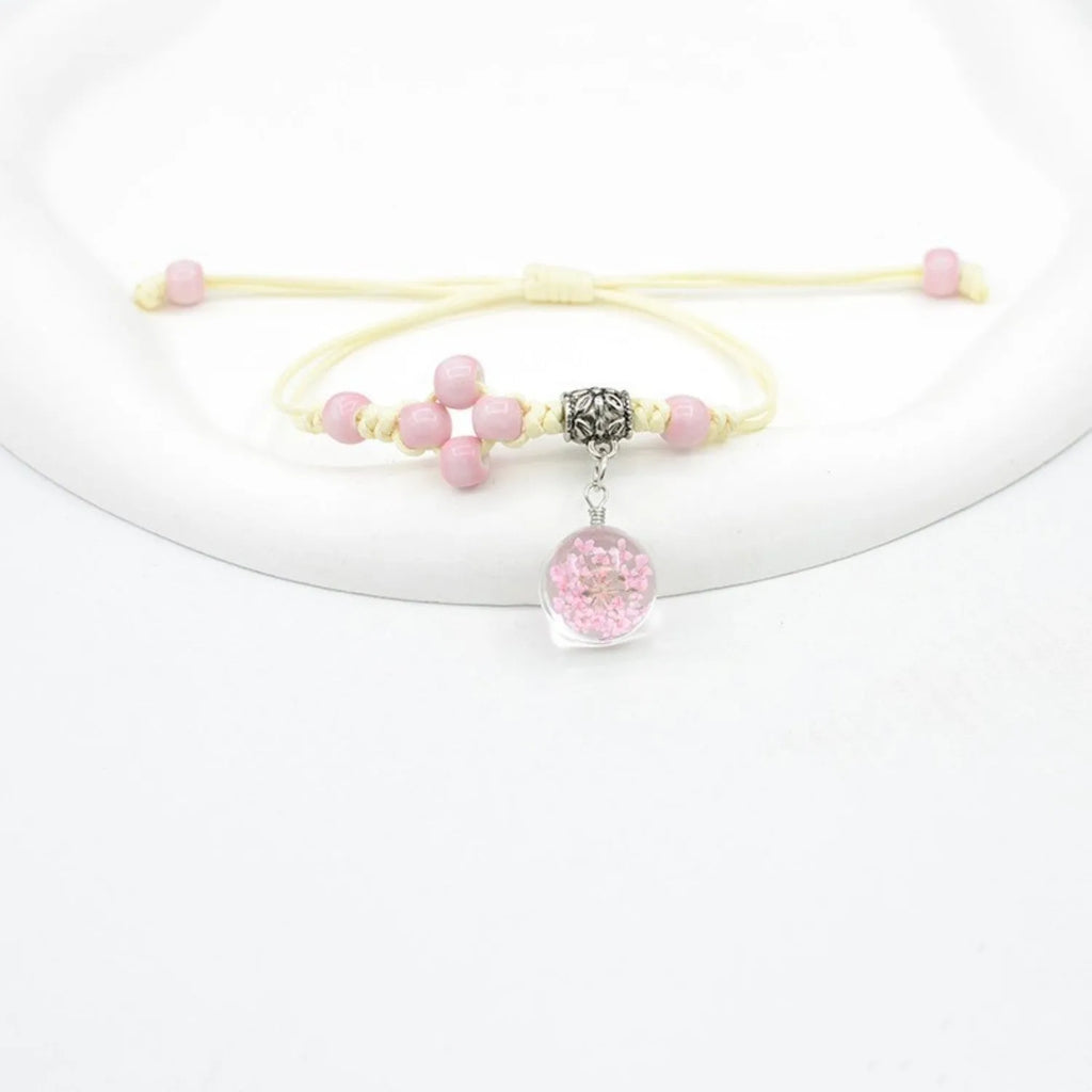 Close-up of a hand-woven glass bracelet with large 1.4cm beads containing real dried flowers.