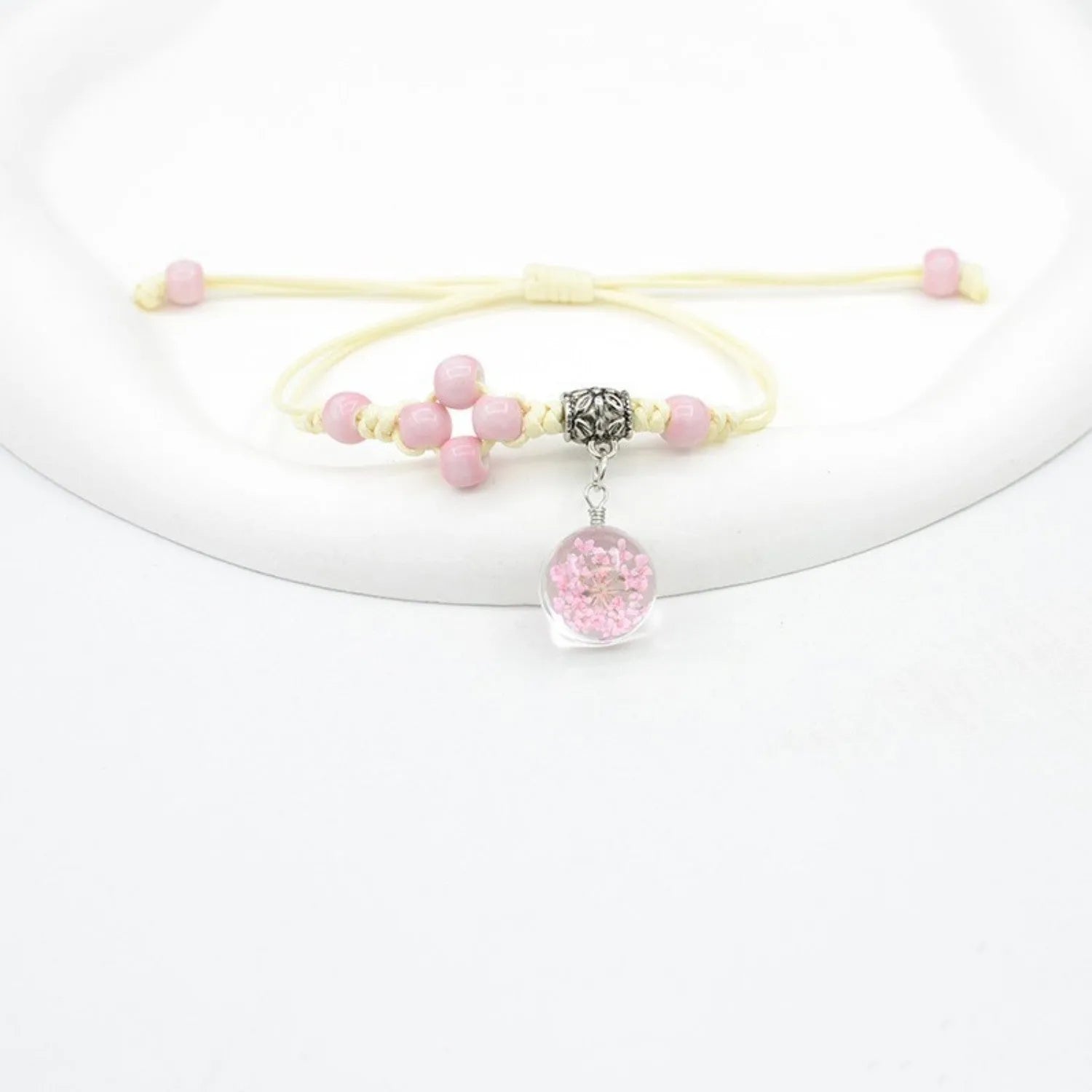 Close-up of a hand-woven glass bracelet with large 1.4cm beads containing real dried flowers.