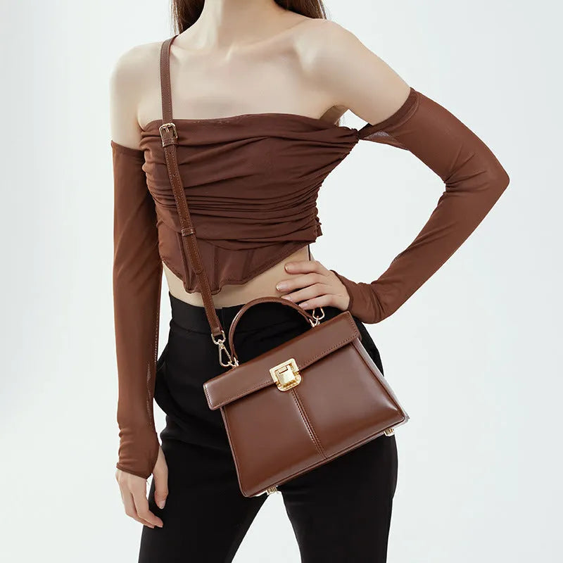 Women's black genuine vachette leather shoulder bag with clasp closure and 120cm strap.