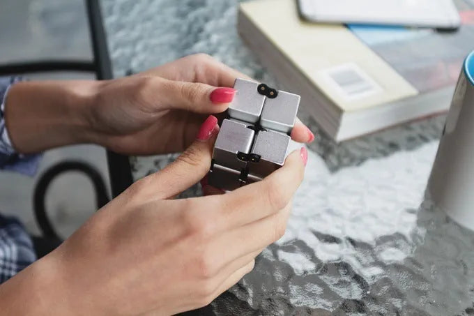 Black zinc alloy infinity cube fidget toy showing rotated cubes, on a white background.