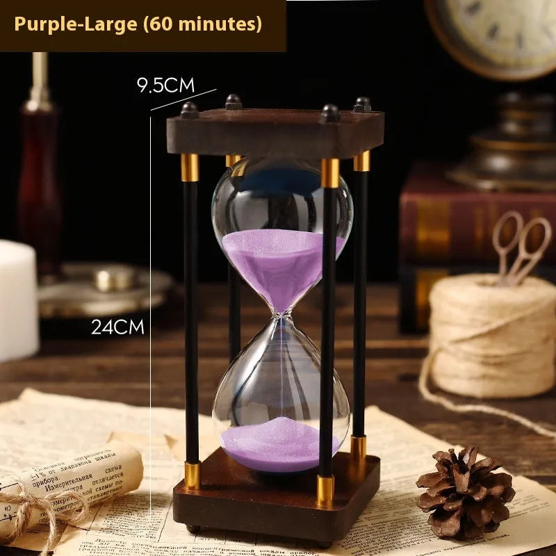 Wooden hourglass timer with solid wood frame and coloured sand on a desk
