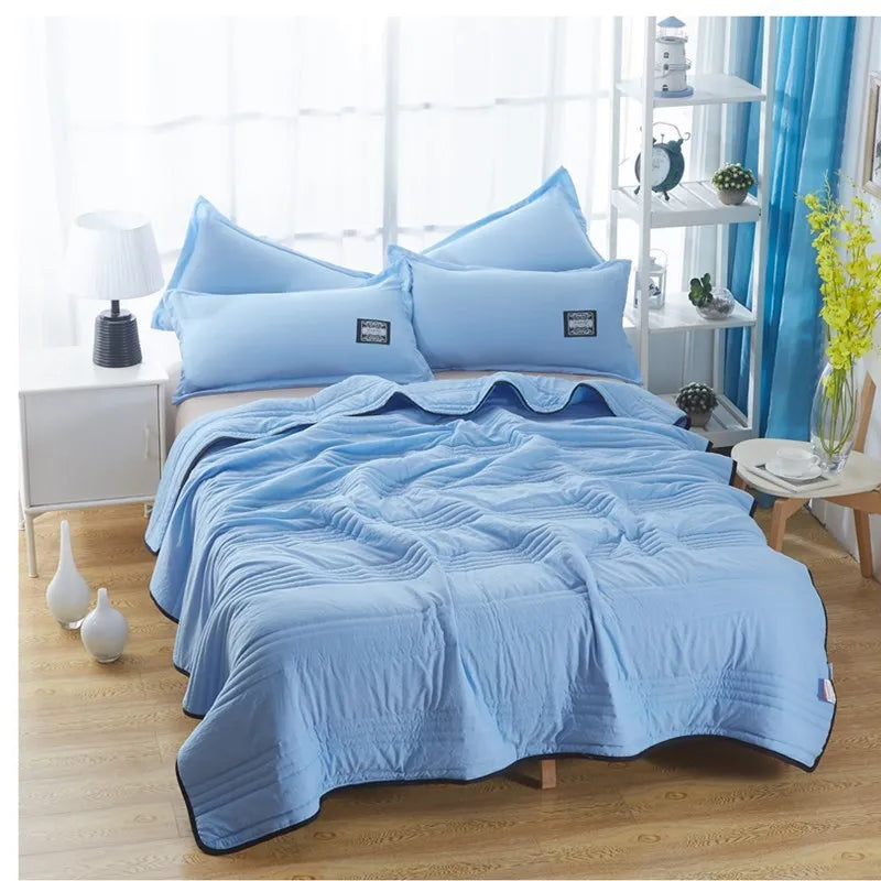 Lightweight seersucker summer quilt in various colours on a bed