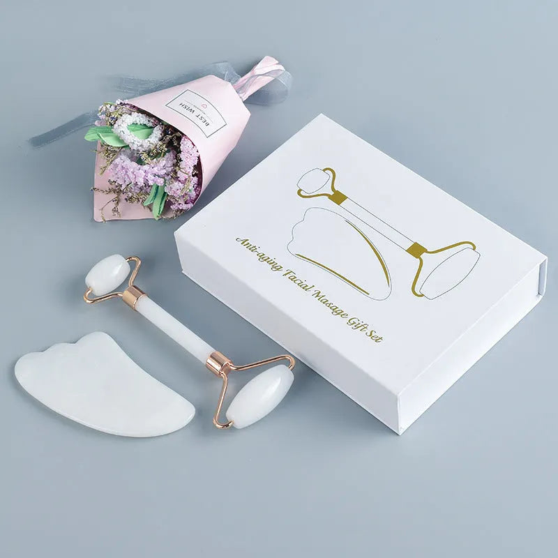 White jade double-headed roller and matching scraping board set on a flat surface.