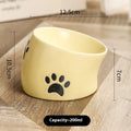 Ceramic cat food bowl with high foot base in a cat's paw print design