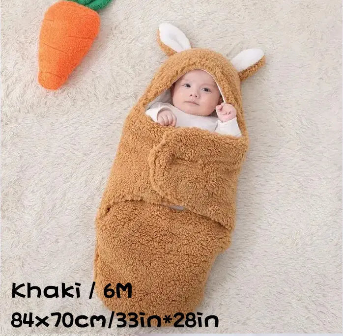 Baby wearing a grey adjustable fleece swaddle sleep sack with velcro wings