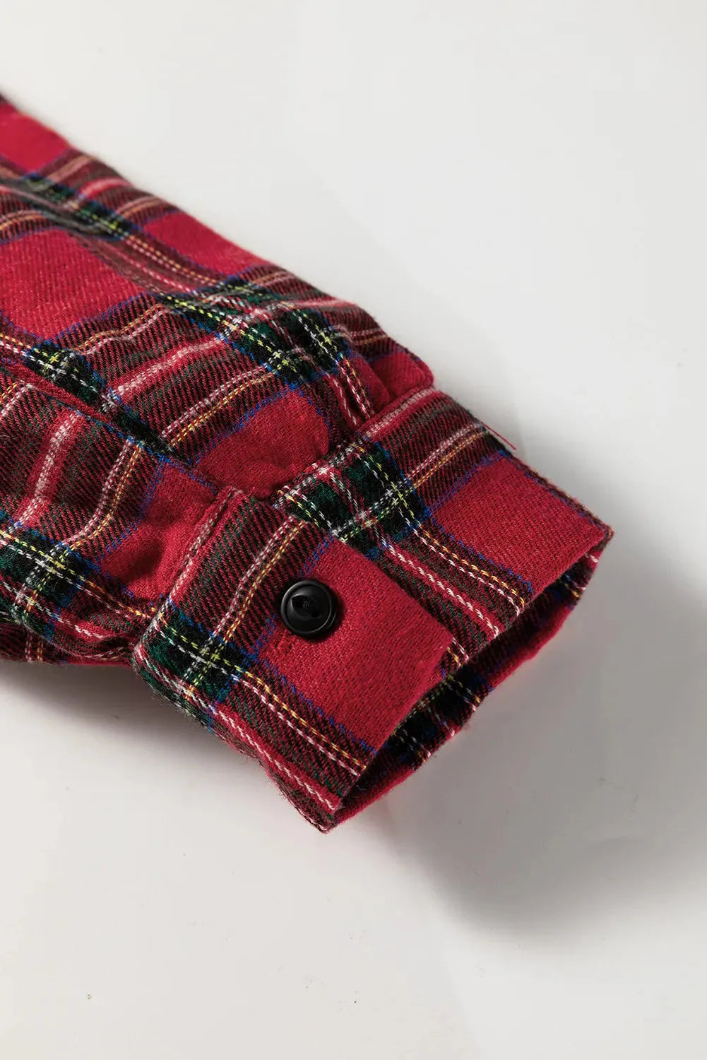 Red and black plaid mini dress with a shirt collar, long sleeves, half-button front, and a ruffled hem.