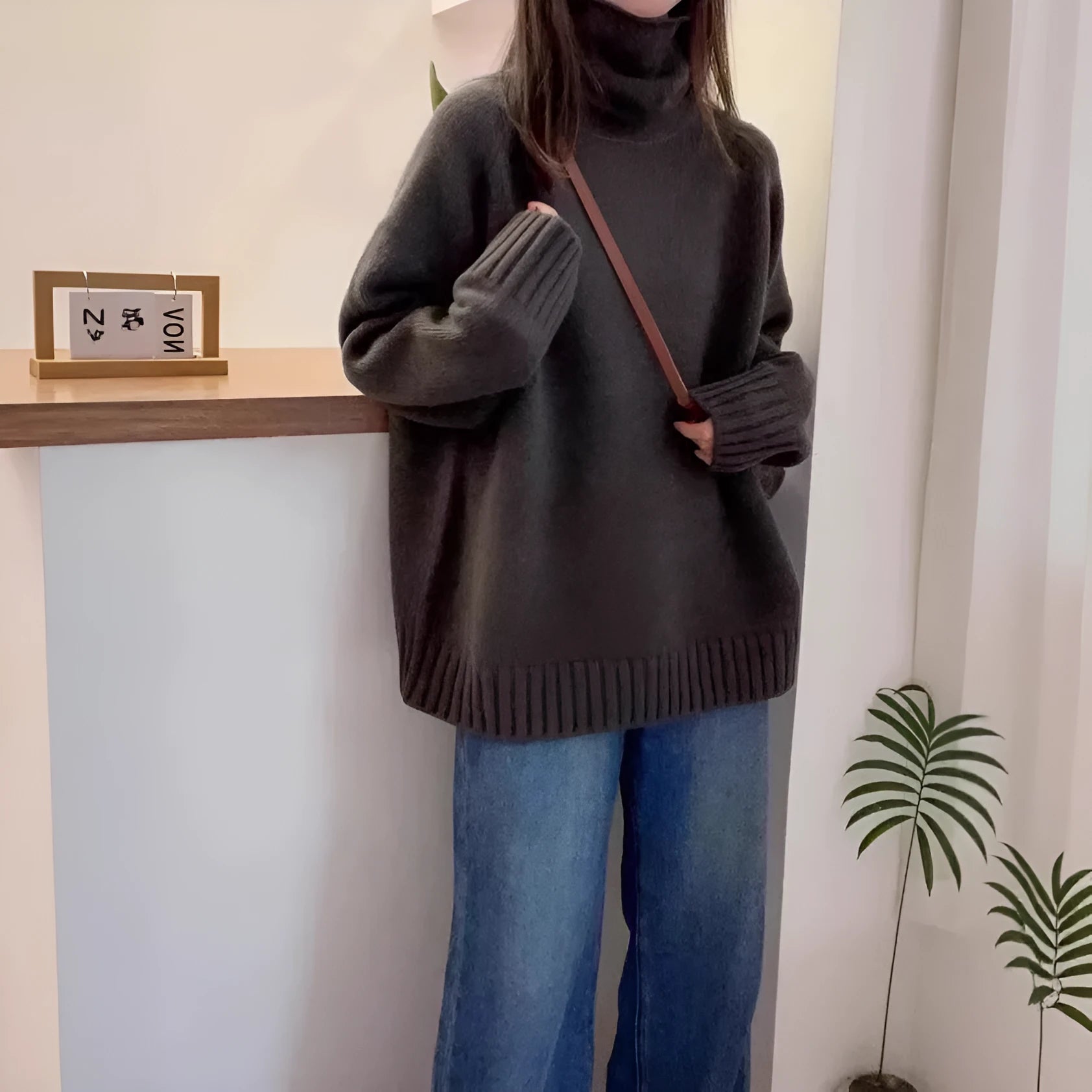 Women's loose fit turtleneck sweater with a thick, textured curling pile collar in a solid colour.