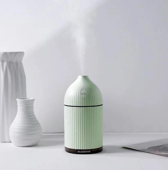 White USB-powered ultrasonic aromatherapy diffuser and humidifier with LED light on a wooden surface.