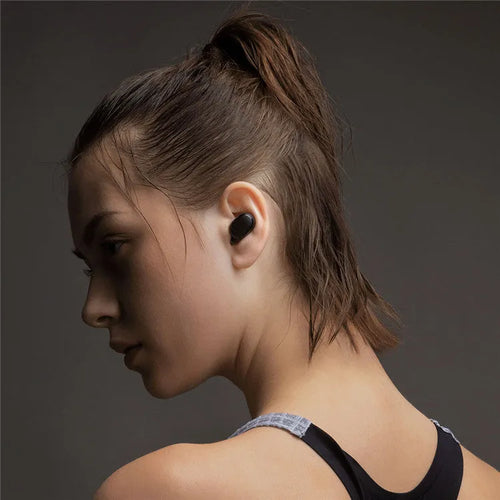 Black Redmi AirDots true wireless earbuds next to their compact charging case.