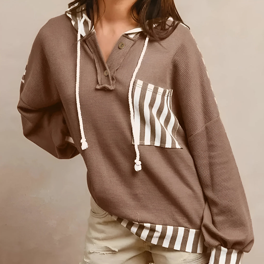 Straw yellow striped hoodie with waffle texture patchwork, button neck, and drawstring hood laid flat.