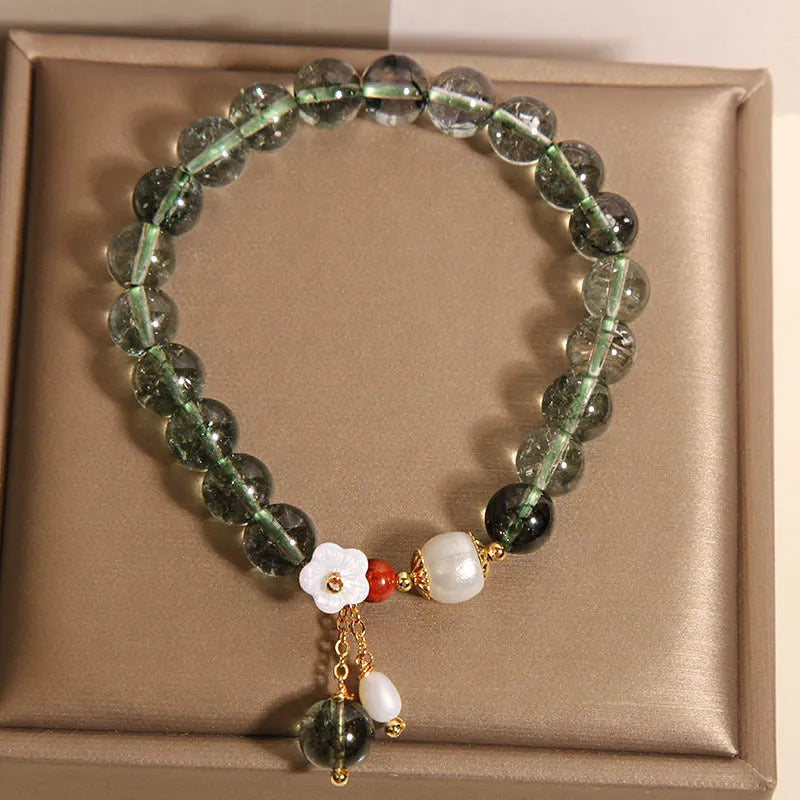 Green phantom quartz crystal bracelet for women with small shell flower and Bells of Ireland design details.