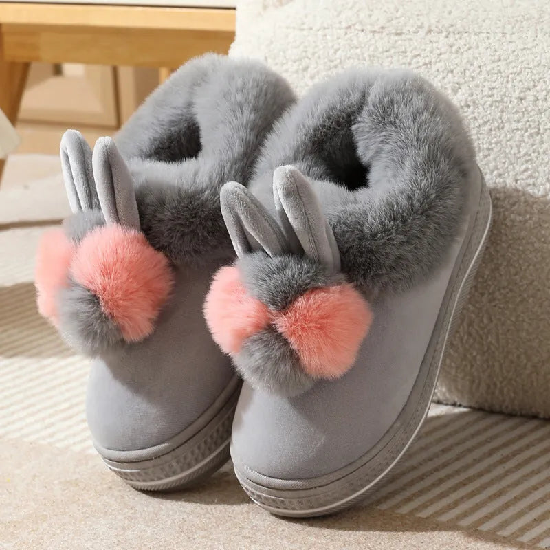 A pair of high-heel winter slippers with a plush fabric upper and a thick TPR sole.