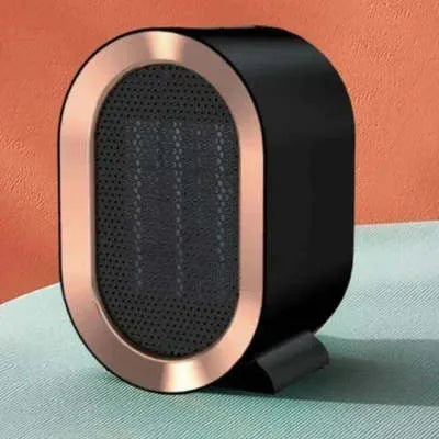 A compact black desktop ceramic fan heater with a mechanical control dial and a UK plug.