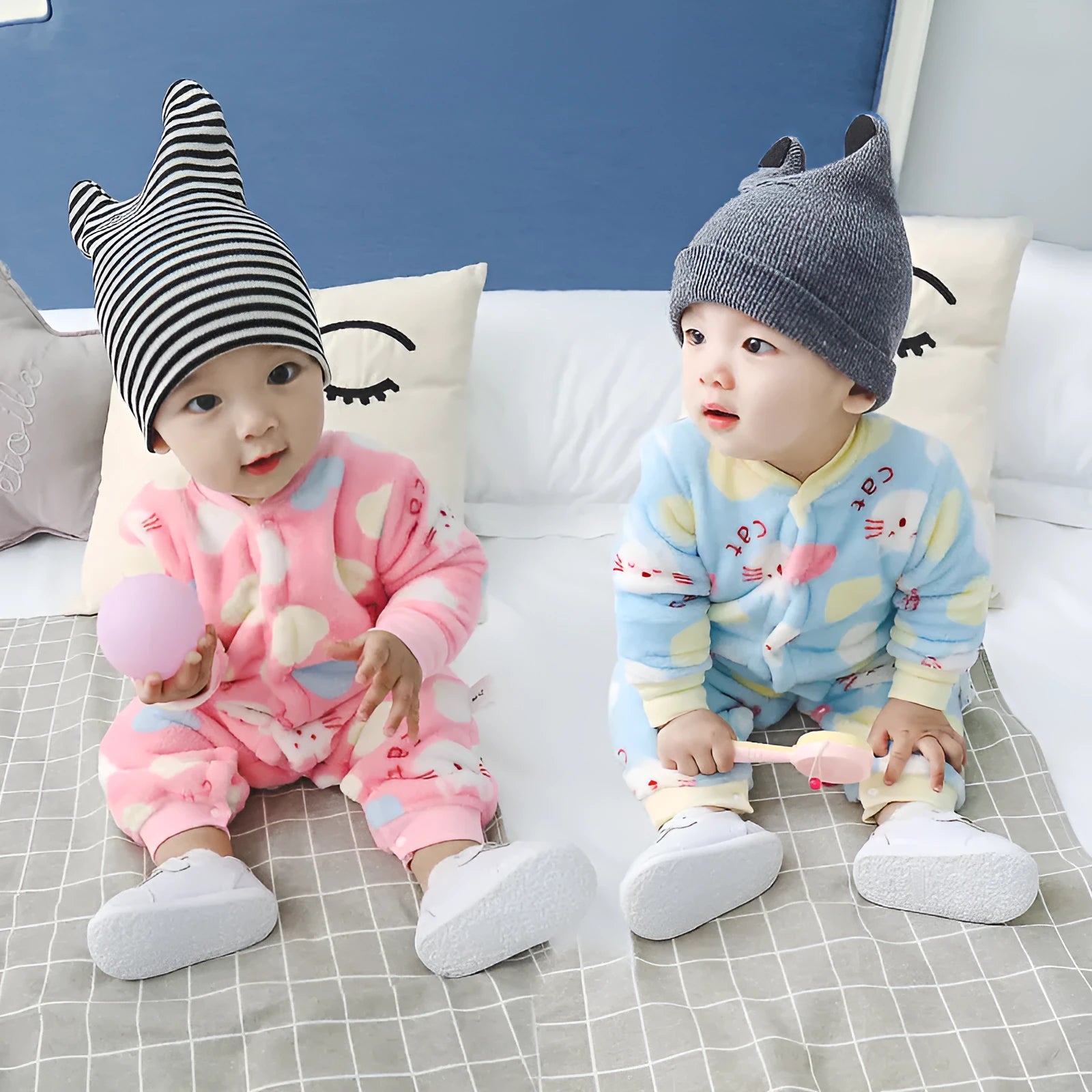 Baby wearing a long sleeve flannel romper with a printed panda pattern in pink and blue.