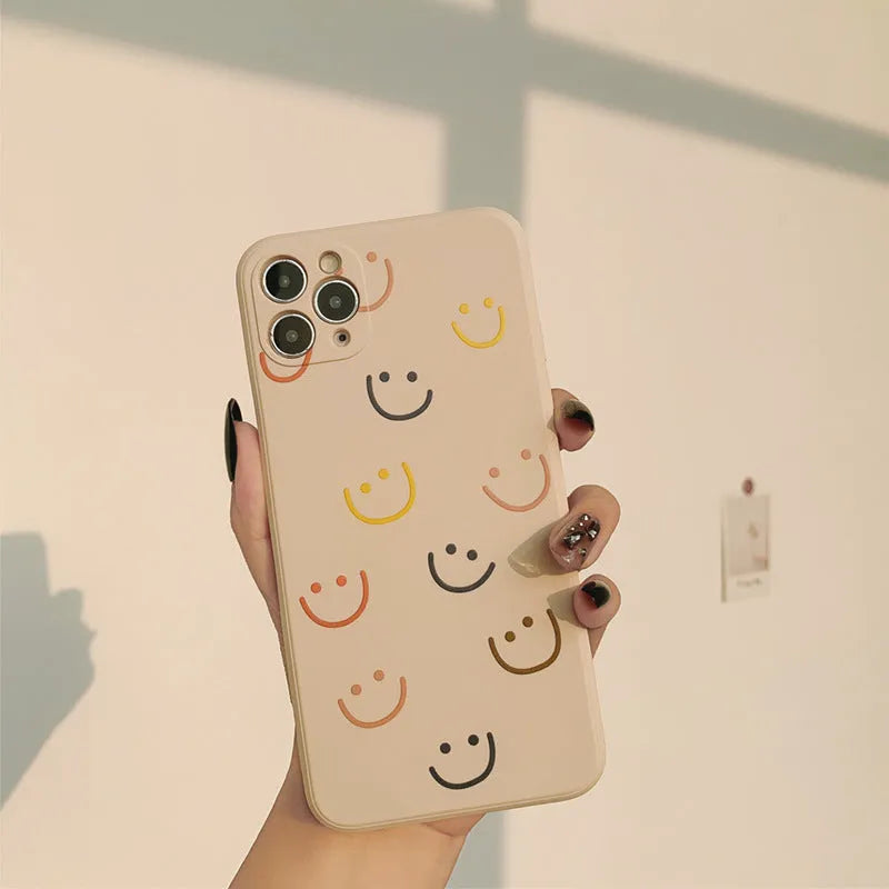 Simple silicone TPU iPhone case with a painted smiley face design on a solid colour background.