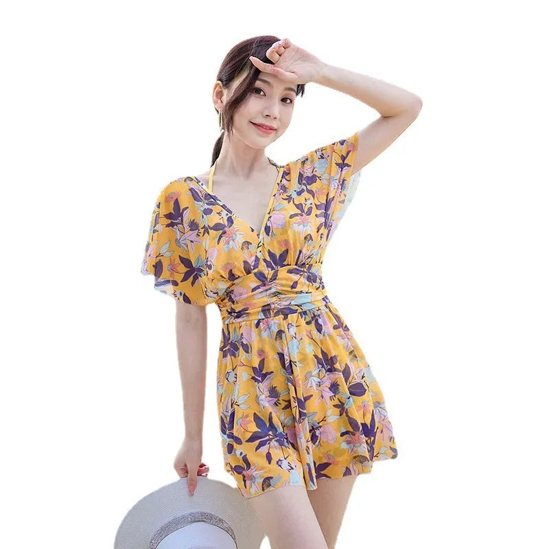 Yellow floral print women's one-piece swimsuit with skirted design.