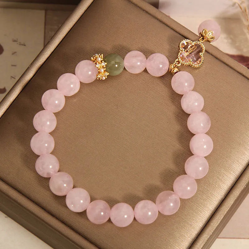Pink crystal women's bracelet with four-leaf clover pendant charm and rhinestone decoration.