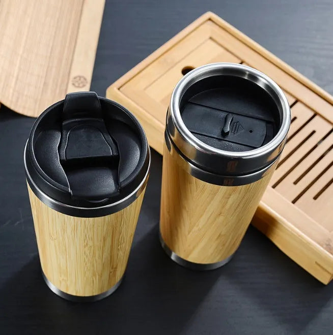 Bamboo travel coffee cup with stainless steel interior, leak-proof lid, and a grey foam pad.
