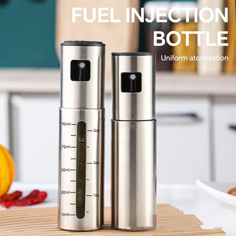 Stainless steel press spray oil injection bottle with glass body and 100ml capacity on kitchen countertop
