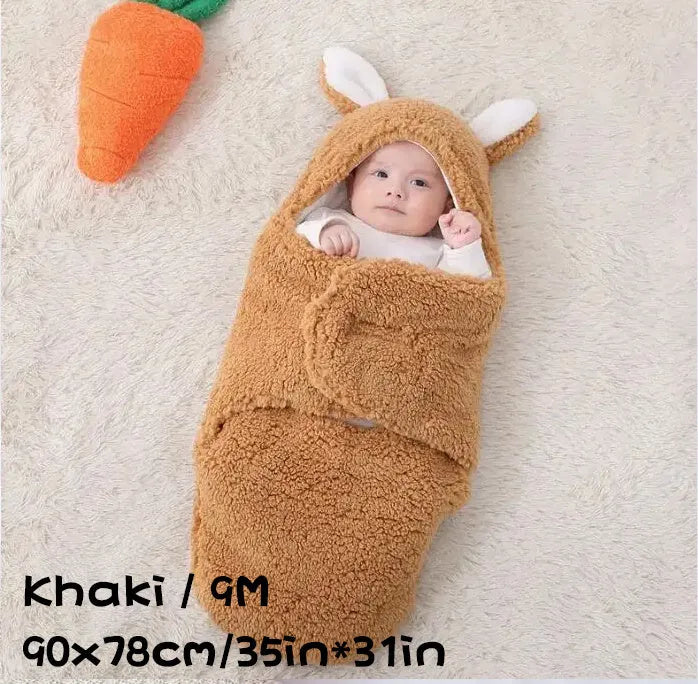 Baby wearing a grey adjustable fleece swaddle sleep sack with velcro wings