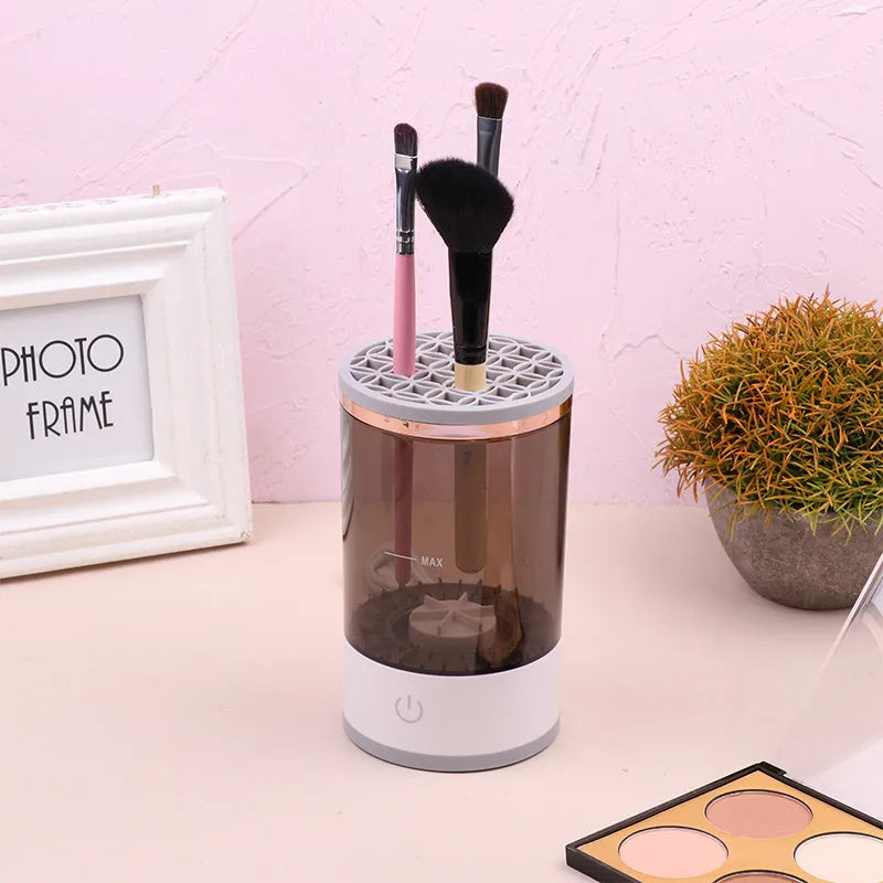 Grey and white portable electric makeup brush cleaner with USB cable.