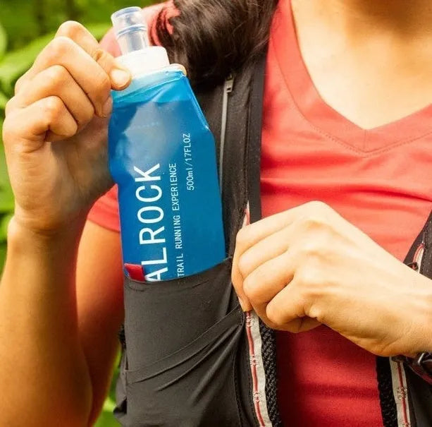 Flexible silicone drinking straw with black carabiner clip against outdoor background