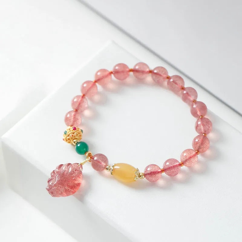 Women's polished crystal beaded bracelet with strawberry quartz and a nine-tail fox charm.