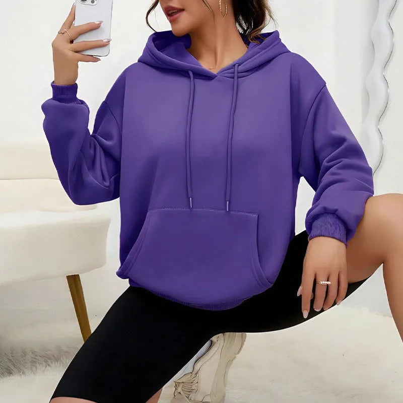 Women's loose grey drawstring pocket sweatshirt on a hanger showing front detail.