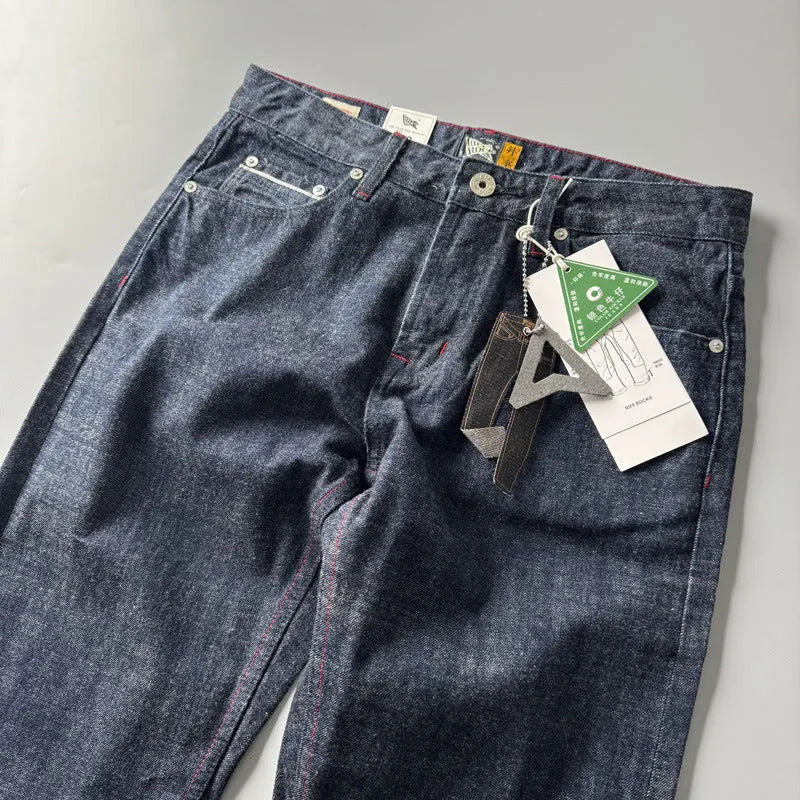 Man wearing blue straight leg denim jeans with a mid waist, showcasing the classic five-pocket retro design.