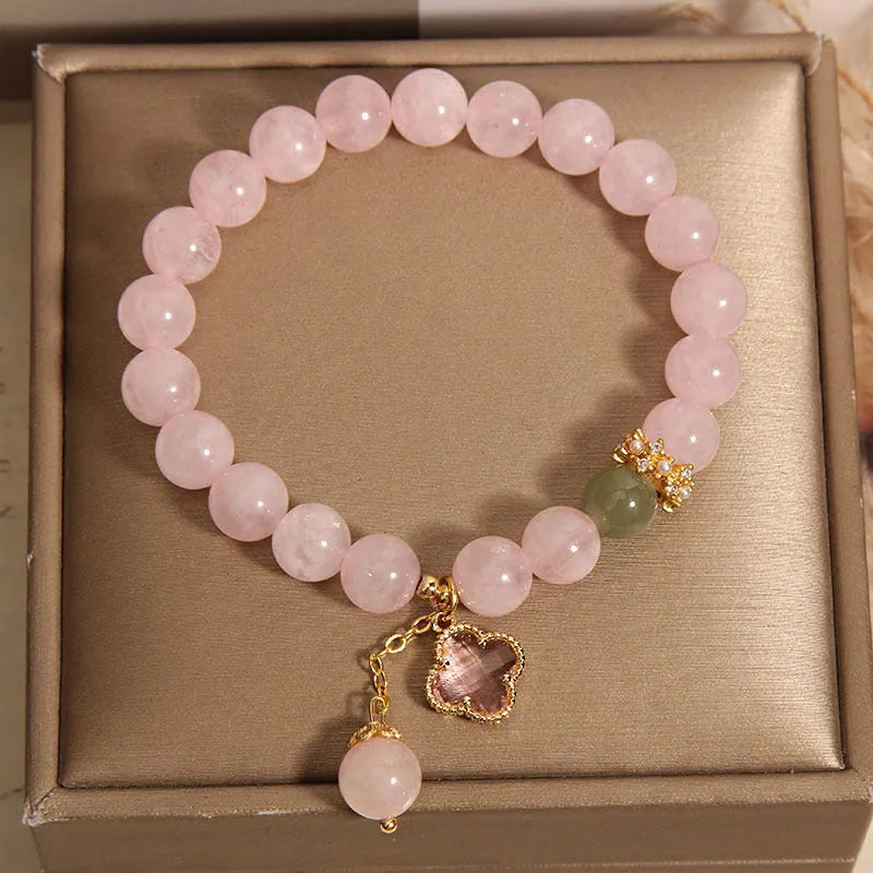 Pink crystal women's bracelet with four-leaf clover pendant charm and rhinestone decoration.