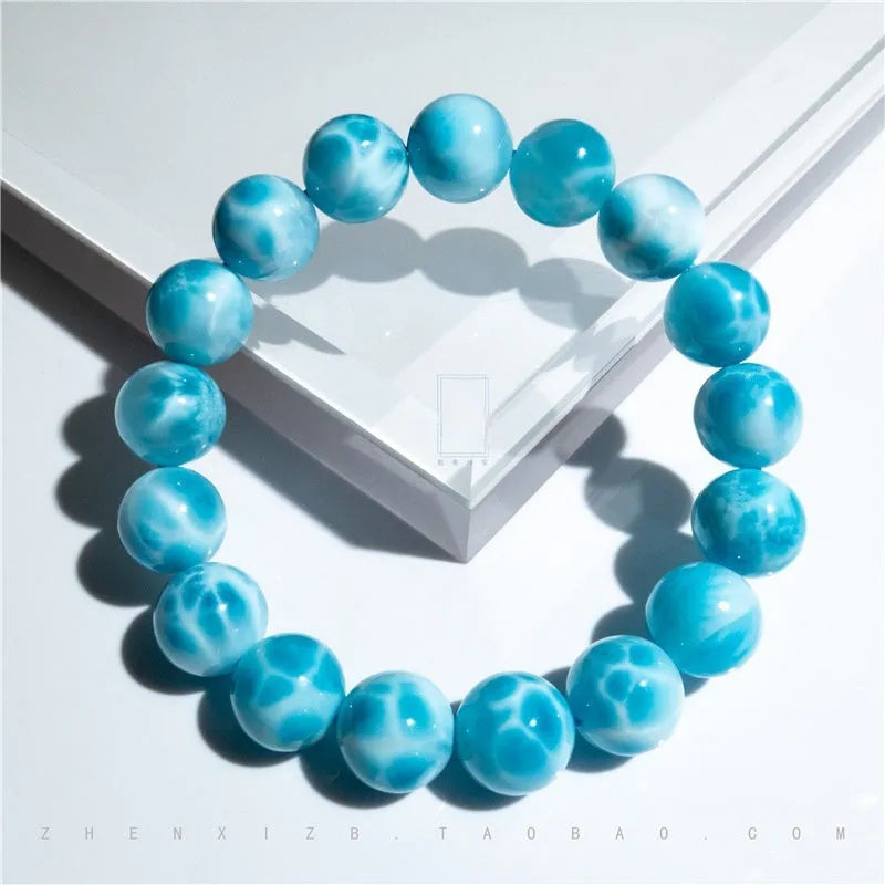 Blue bodhi bracelet with a sea-pattern natural crystal stone and small pearl accents on a wrist.