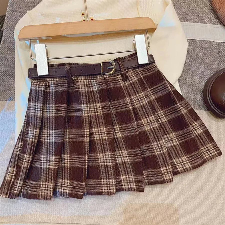 Girls' red and black plaid pleated A-line skirt made from cotton blend fabric.