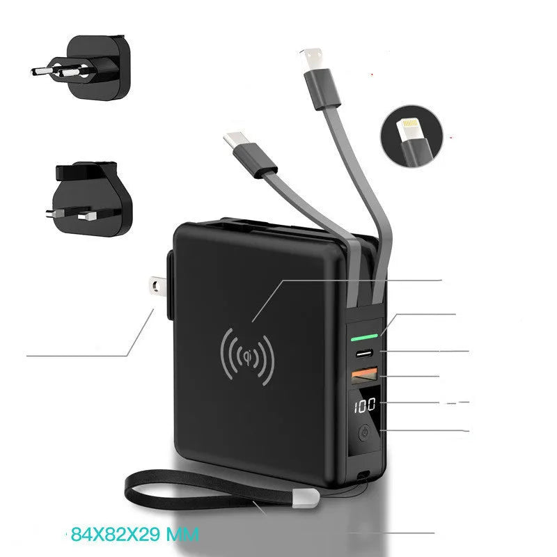 Black Super QI wireless power bank with integrated folding plug shown on a table next to a smartphone.