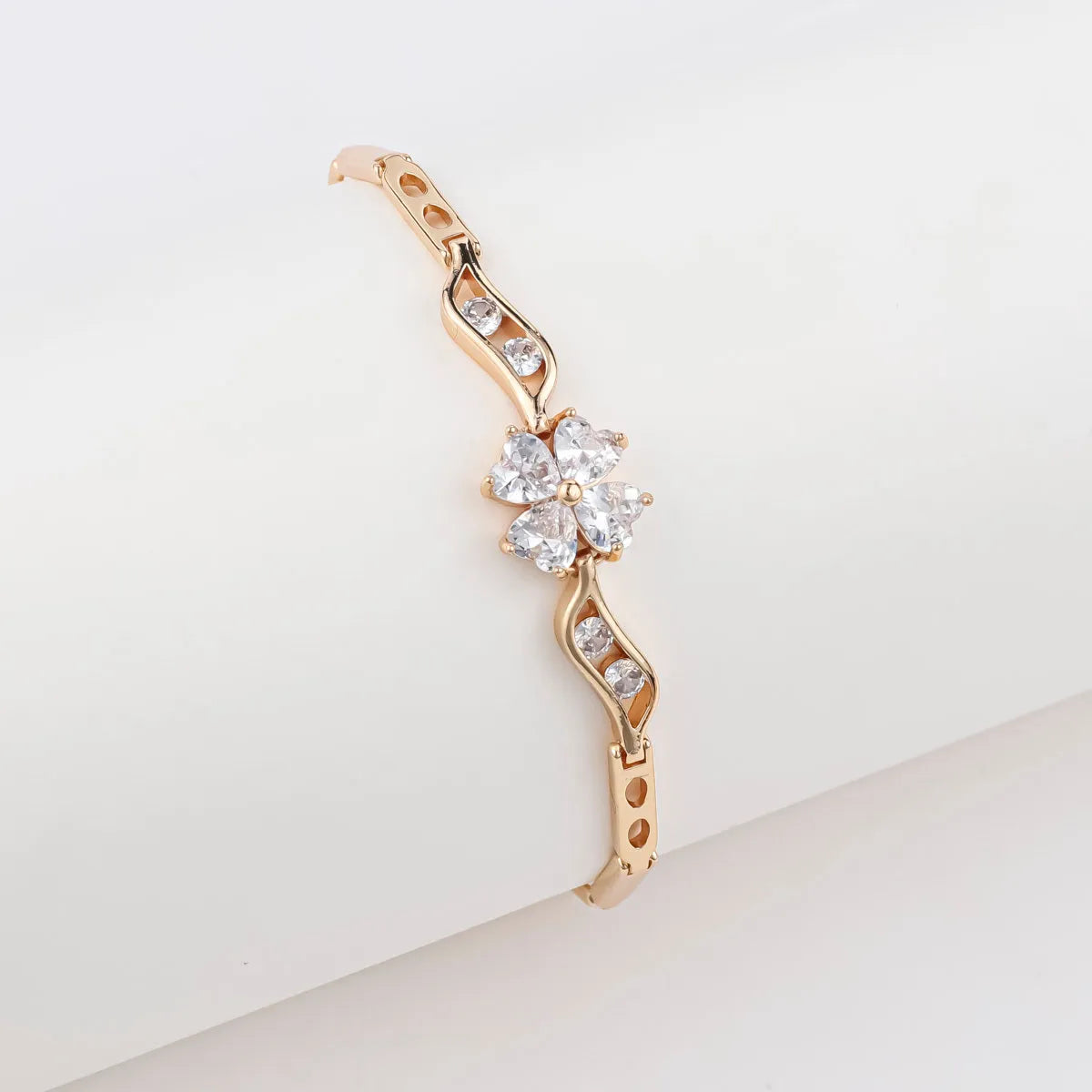 18K gold-plated butterfly clover brass bracelet with zircon stone on plain background