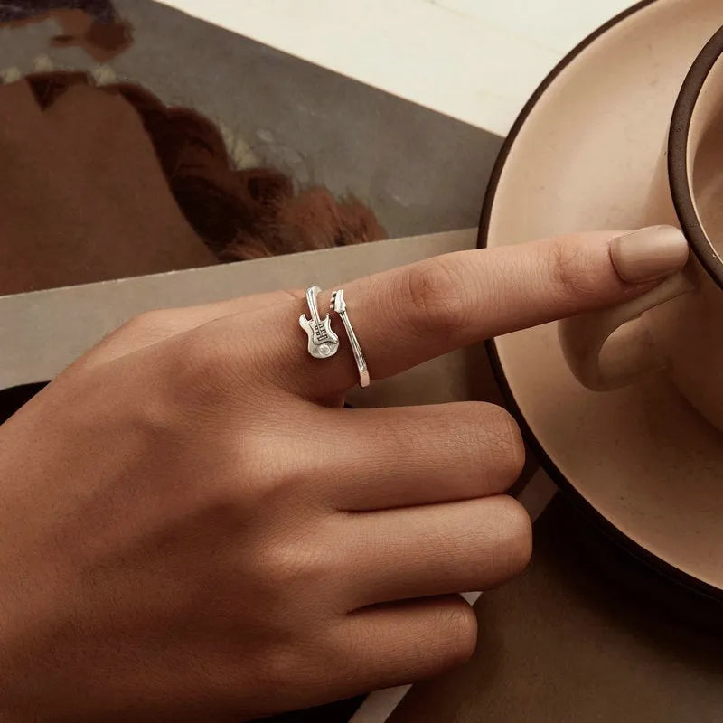 S925 silver oxidised open ring with guitar ornament on neutral background