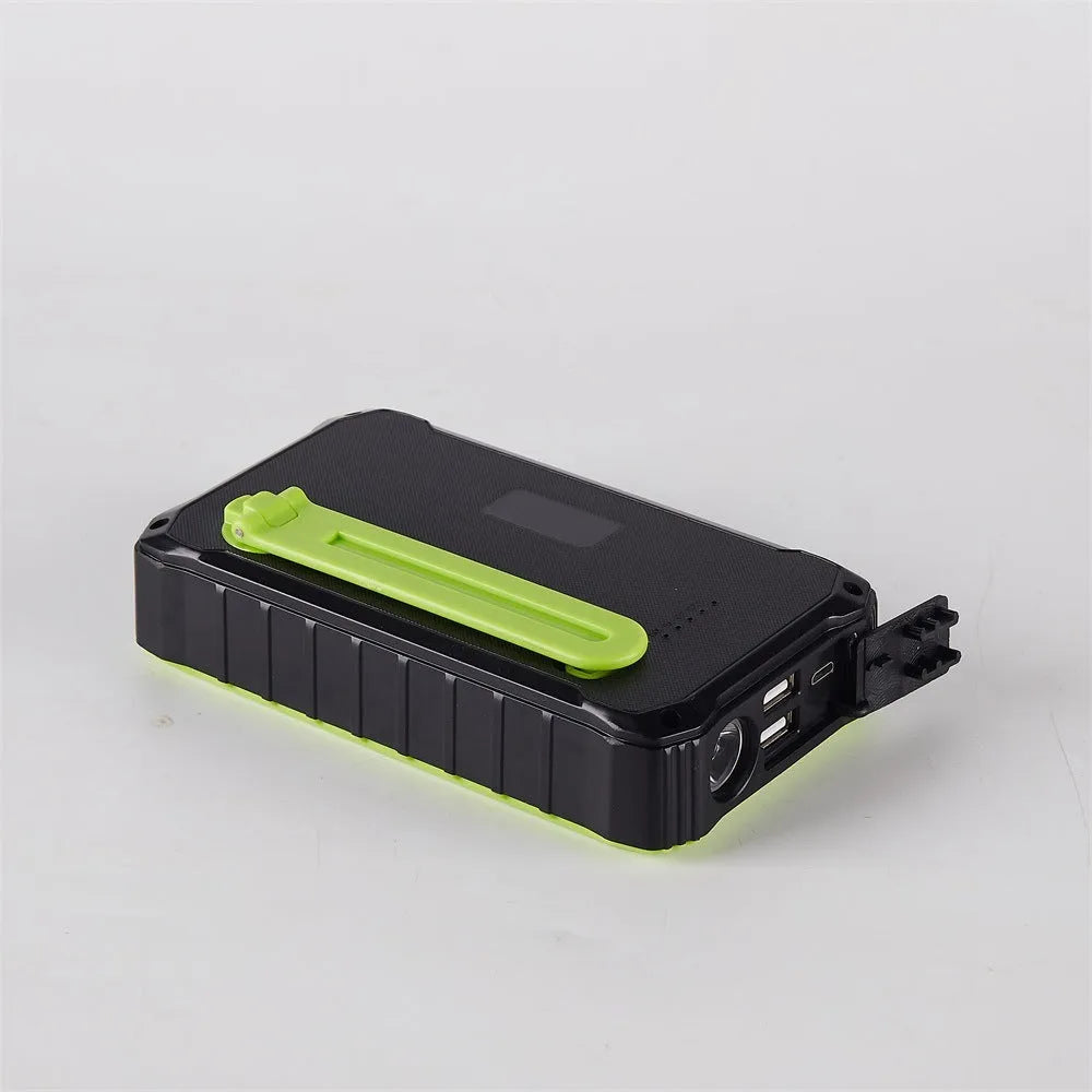 Orange and green portable solar hand crank power bank with USB ports and LED light.