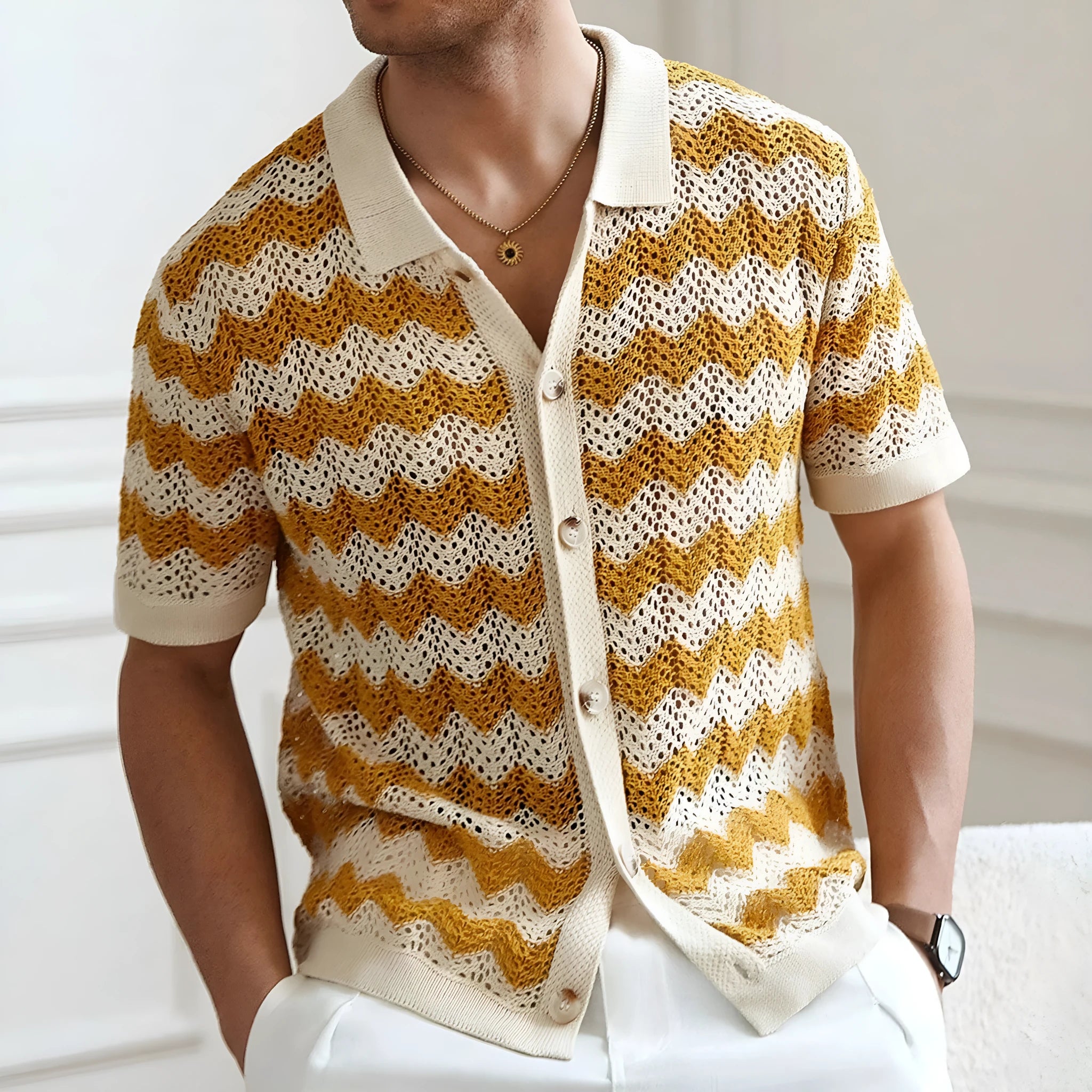 Man wearing a blue short-sleeve sweater with a textured jacquard knit pattern.