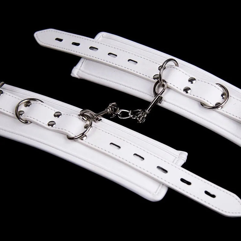 White PU sponge bondage set showing handcuffs, foot cuffs, and a neck scarf for adult play.