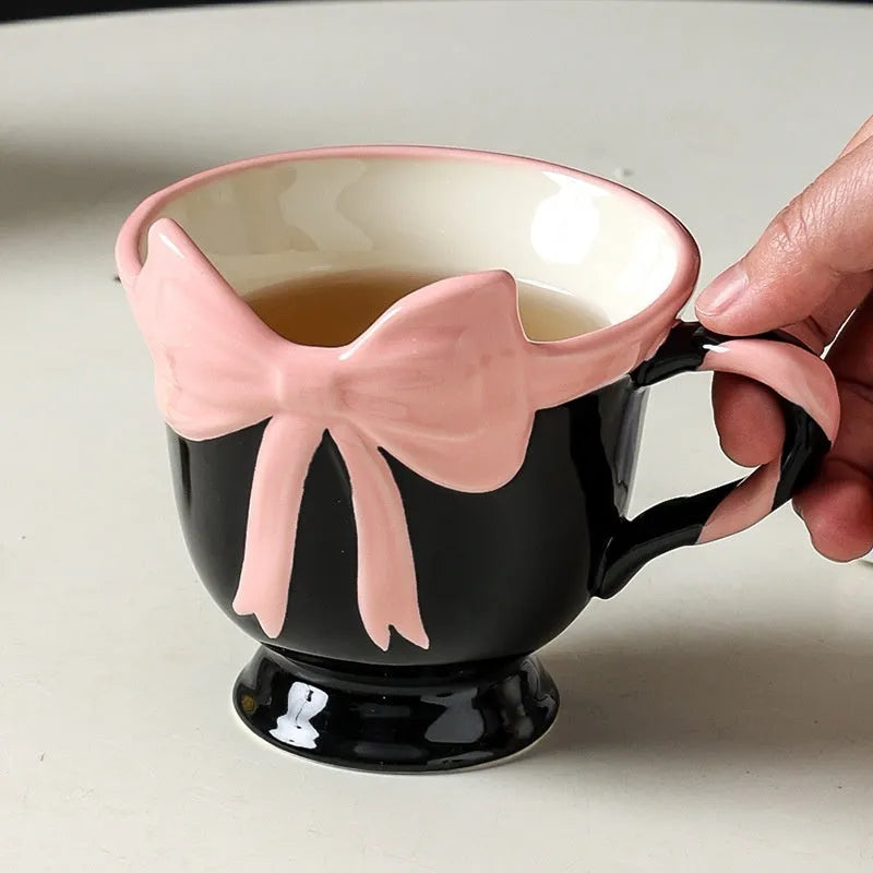 Ceramic mug with heart bow design in white powder and black pink colours.