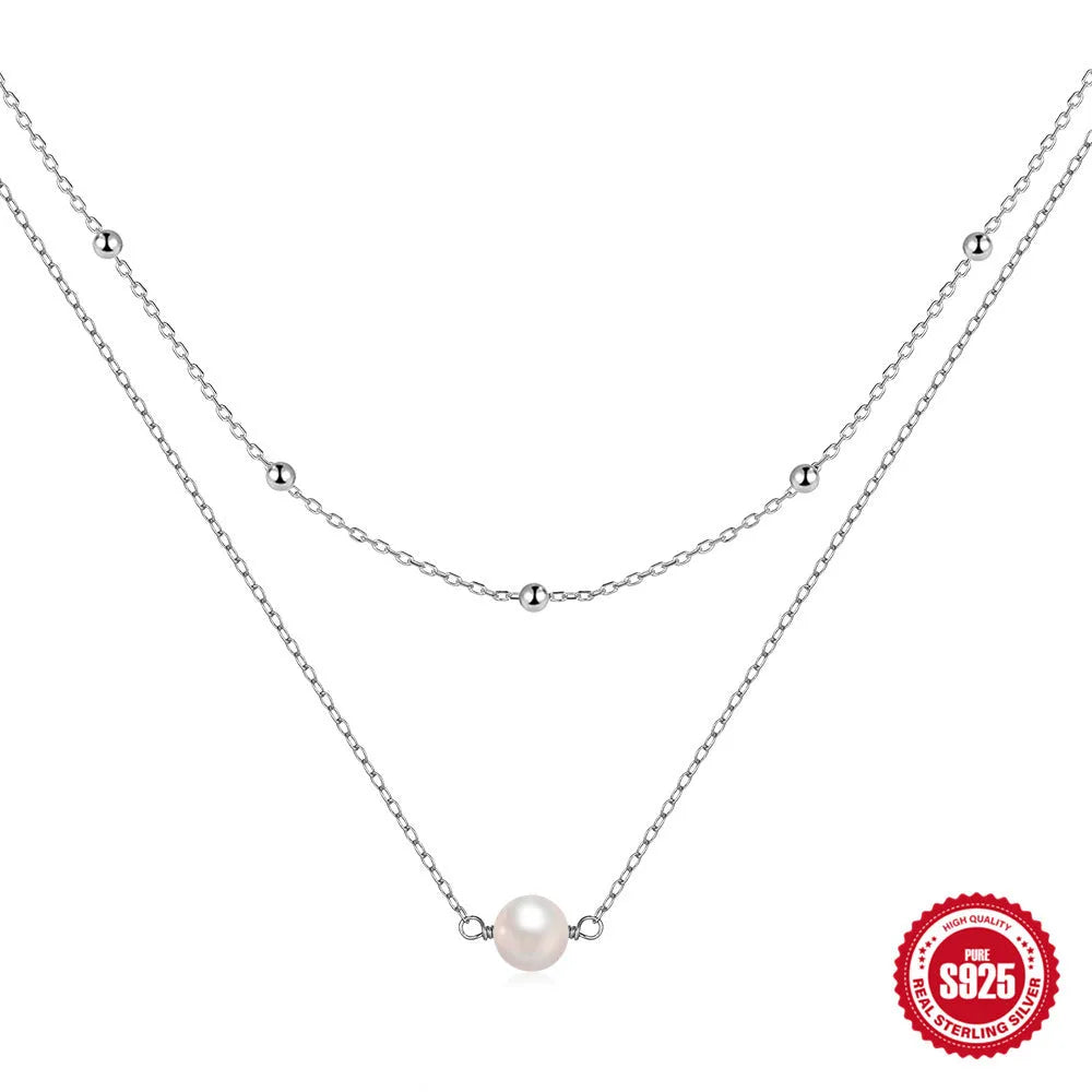 Sterling silver geometric pendant necklace with two pearls, on a ball bead chain, shown in gold and white gold plating.
