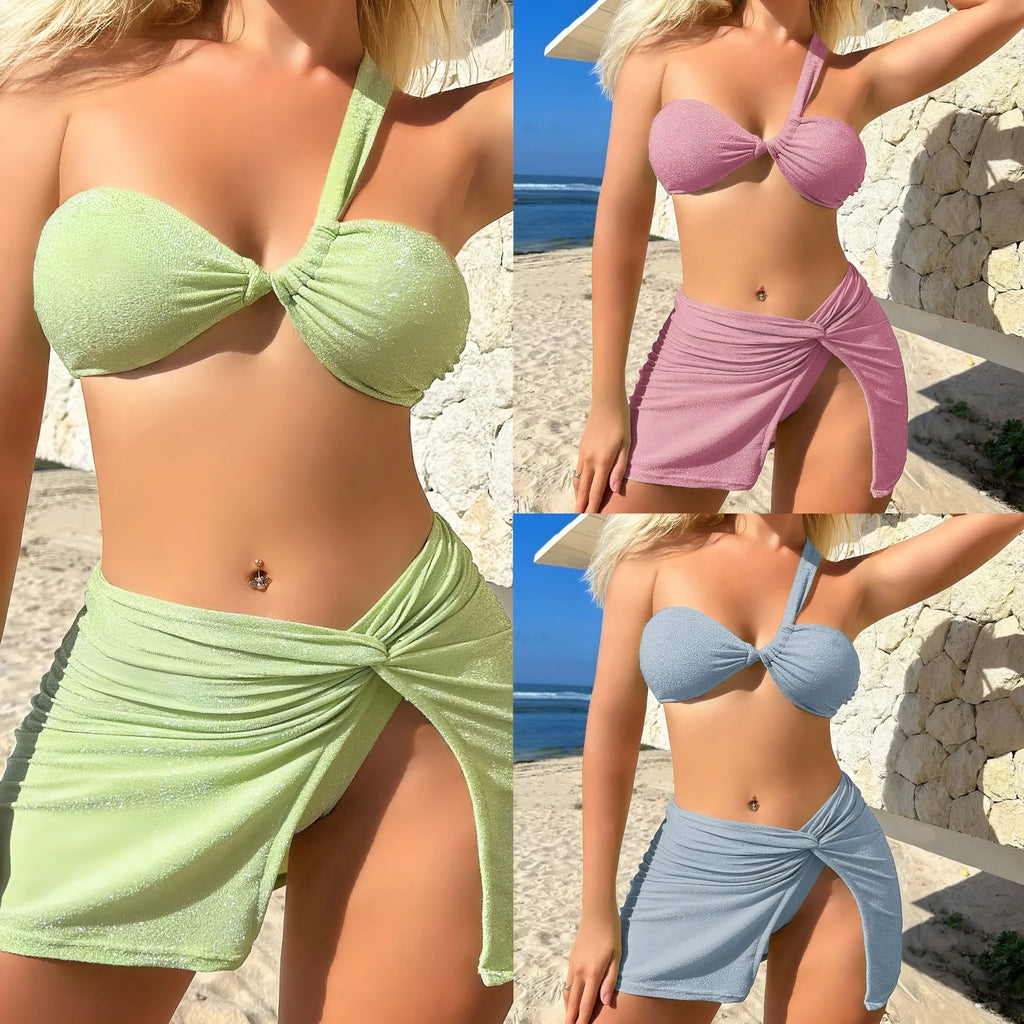 Women's light green one-shoulder swimsuit top with matching briefs and skirt on a hanger.